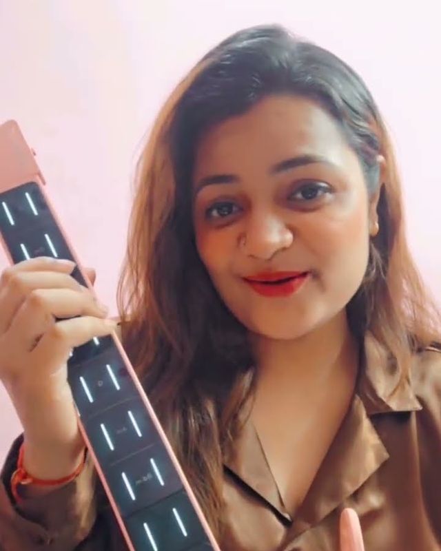 Paaridhi Sharma holding a guitar while recording a cover